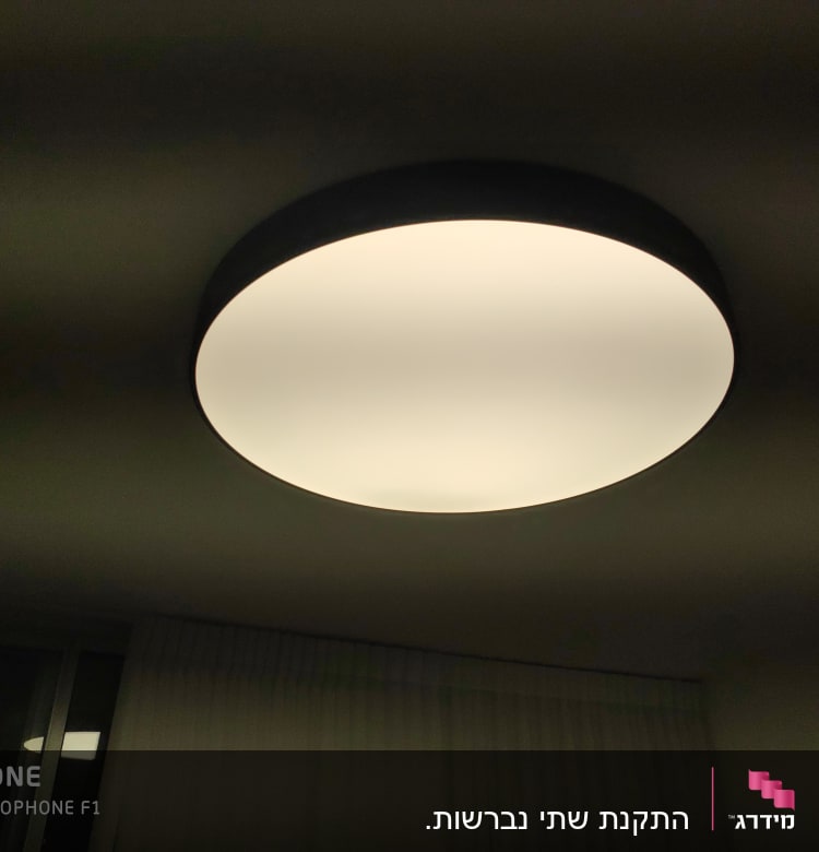 מנורת תקרה עגולה מוארת בחדר חשוך
